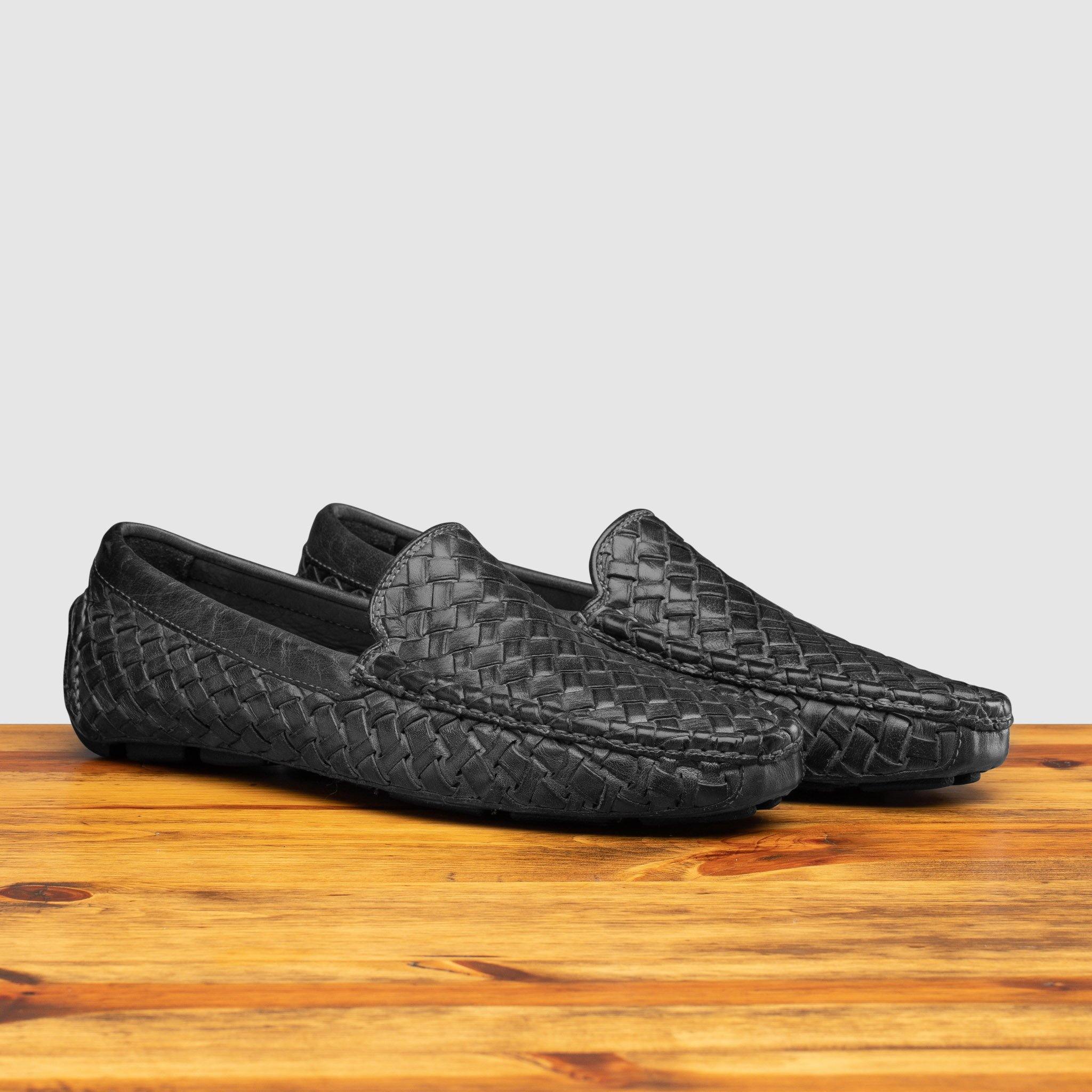 Profile of E945 Calzoleria Toscana Black New Rendo Woven Driver on top of a wooden table